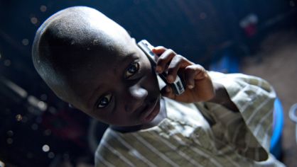 Un ni&ntilde;o de la aldea nigerina de Takalafiya-Lapai utiliza un tel&eacute;fono m&oacute;vil.