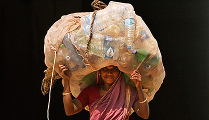 Una mujer india con botellas de plástico recicladas para vender.