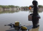 Una mujer etíope recoge agua de un estanque construido para mejorar la resiliencia frente a la sequía.