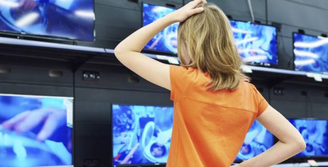 Una mujer trata de elegir una televisión conectada.