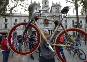 Una ciclista levanta su bicicleta, hecha de bamb&uacute;. 