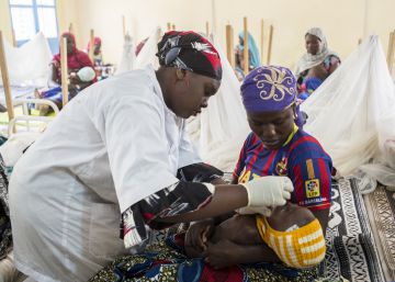 Una enfermera de 22 años, revisa el estado un bebé.