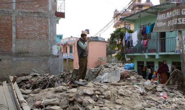 Un hombre sobre escombros en los trabajos de reconstrucción.