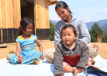 Shreejana Lama, de 27 a&ntilde;os, con sus hijos frente a la casa provisional en la que viven tras el terremoto.