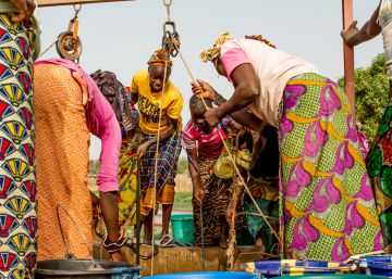 Un grupo de mujeres extrae agua de un pozo del jard&iacute;n de Kolonia, en Mal&iacute;.