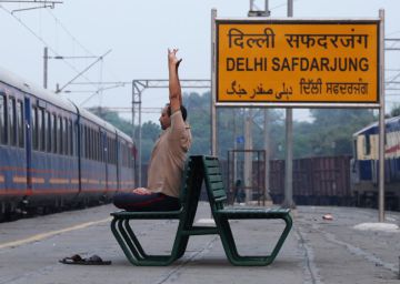 Un empleado del lujoso tren Rajasthan On Wheels huye del ruido en una estación secundaria de Nueva Delhi.