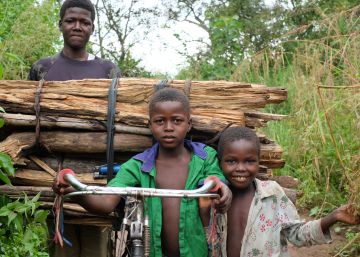 Tres ni&ntilde;os transportan madera en una bicicleta en Sud&aacute;n del Sur.