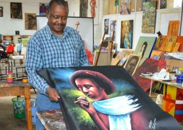 Un beneficiario del proyecto 'Artist for refugees' muestra su obra.