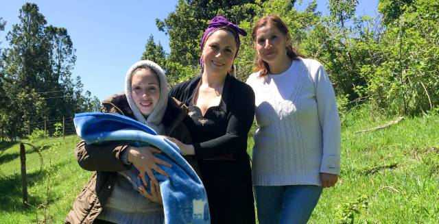 Yoana Aron junto con dos miembros de la comunidad huilliche.