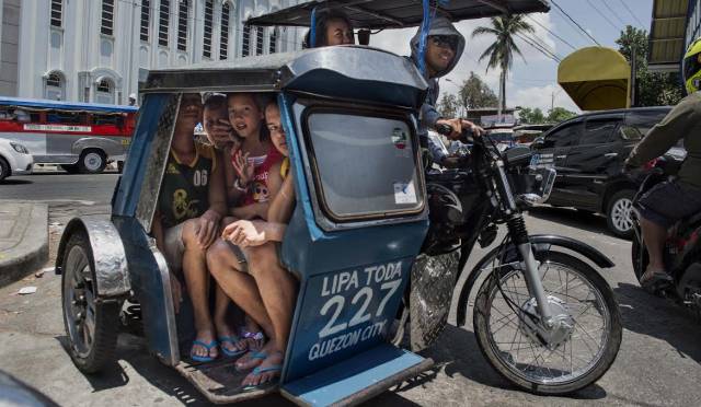 Varias mujeres viajan en un triciclo, los mototaxis de Filipinas.