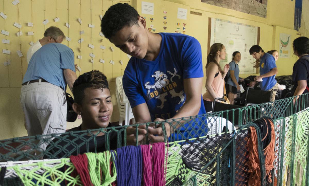 Un joven seleccionando los colores del algodón para el diseño de una hamaca.