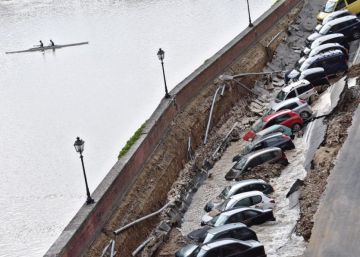 Varios veh&iacute;culos aparecen engullidos por un socav&oacute;n.