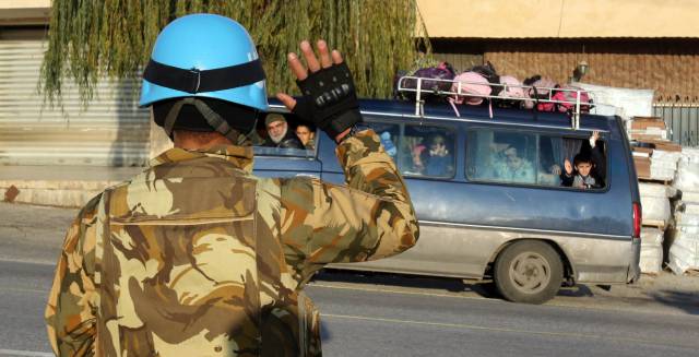 A Unifil soldier waves to a school bus in Lebanon.