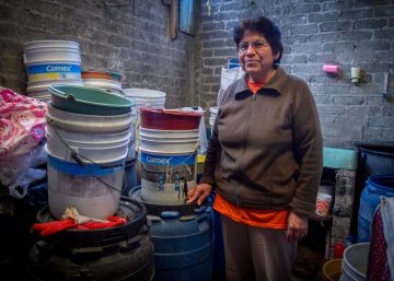 Una mujer con los cubos que usa para recoger agua de lluvia.