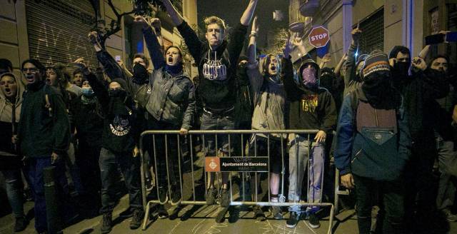 Un grupo de manifestantes grita frente a un cordón policial en Gràcia.