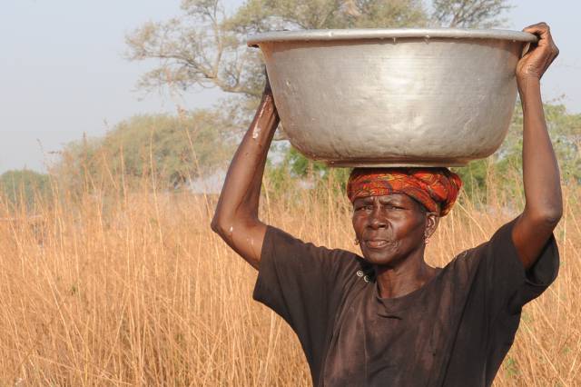 Una mujer carga con un bidón de agua en Burkina Faso.