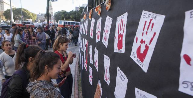 Women pay homage to victims of violence.