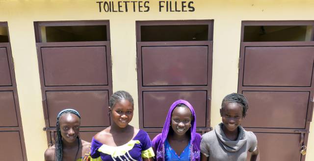 Un grupo de adolescentes frente a las puertas de los aseos para chicas, en una escuela de Mbour (Senegal).