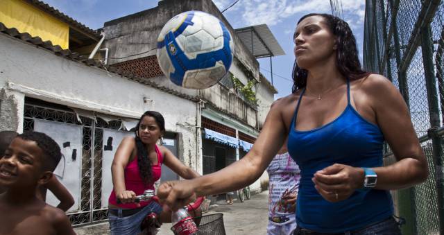 Aline  juega con una pelota de fútbol en la favela no pacificada Vigario Geral, de Río de Janeiro.
