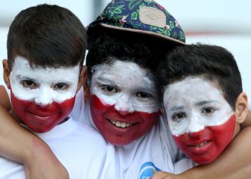 Tres peque&ntilde;os aficionados con la cara pintada con los colores de Polonia. 