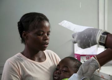 Una madre angoleña sostiene a su hijo, que sufre de fiebre amarilla.