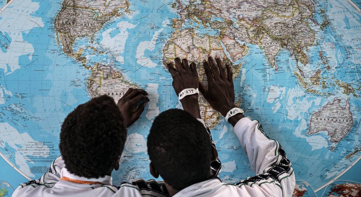 Dos menores de Gambia solicitantes de asilo en Italia, discuten sobre el viaje que han realizado en el puerto de Pozzallo, Sicilia.