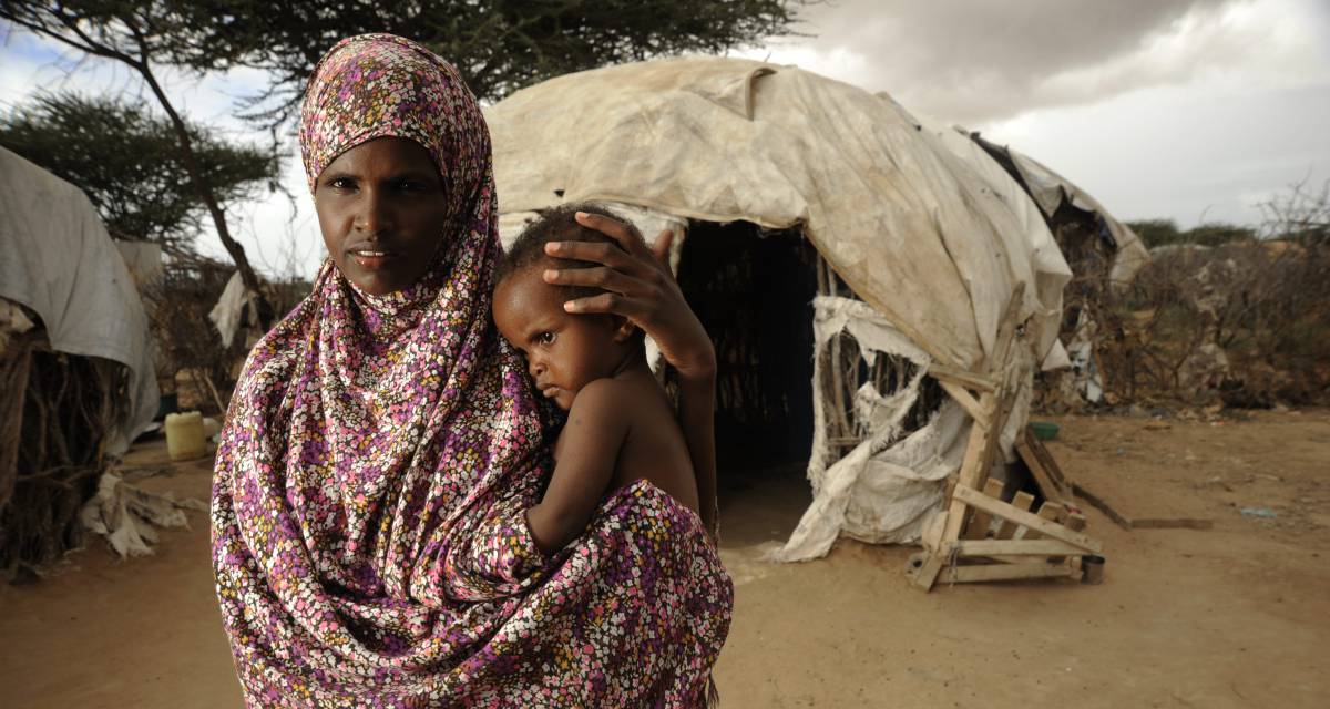 Una mujer somalí posa con su hijo frente a su refugio en el campo de Dadaab, Kenia. 