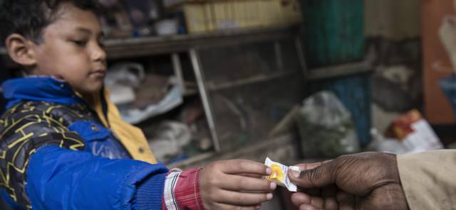 Un niño recibe un caramelo en la tienda de Jawahar Lal.