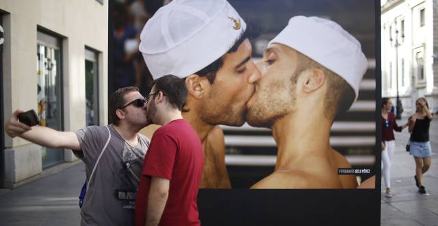 Dos chicos se besan frente a una de las fotograf&iacute;as de 'Orgullo de Sevilla'.