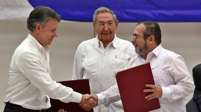 Santos y Timochenko firman ante Castro.