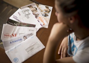 Una mujer indecisa en su voto mira los sobres de propaganda electoral recibidos de los principales partidos que se presentan a las próximas elecciones del 26 de junio.rn 
