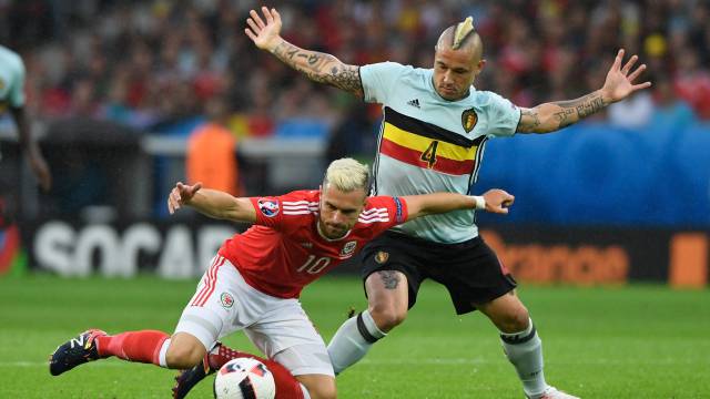 Nainggolan y Ramsey luchan por un balón.