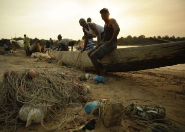 Unos pescadores arreglan las redes tras una jornada de pesca en Sierra Leona.