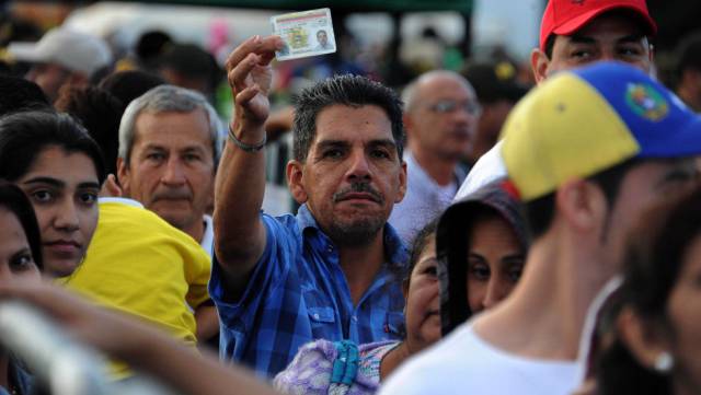 Un venezolano muestra su carnet antes de cruzar la frontera.