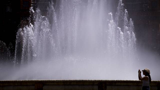 Una chica toma una fotograf&iacute;a en la Plaza de Espa&ntilde;a, junto a la fuente.