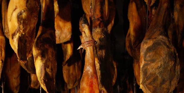 Ham legs being cured at Embutidos Fermín.