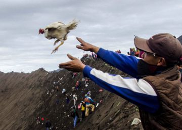 Un miembro de la tribu Tengger lanza un pollo como ofrenda al Monte Bromo.