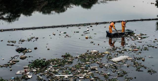 Dos trabajadores recogen vertidos.
