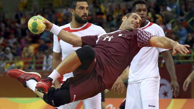 El qatarí Bassel Alrayes en el aire a punto de lanzar el balón a portería en el partido de balonmano contra Túnez.