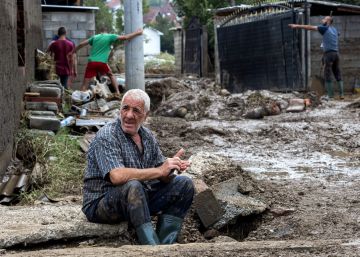 Un anciano descansa mientras sus vecinos limpian sus casas inundadas en el pueblo Stajkovci de Skopie.