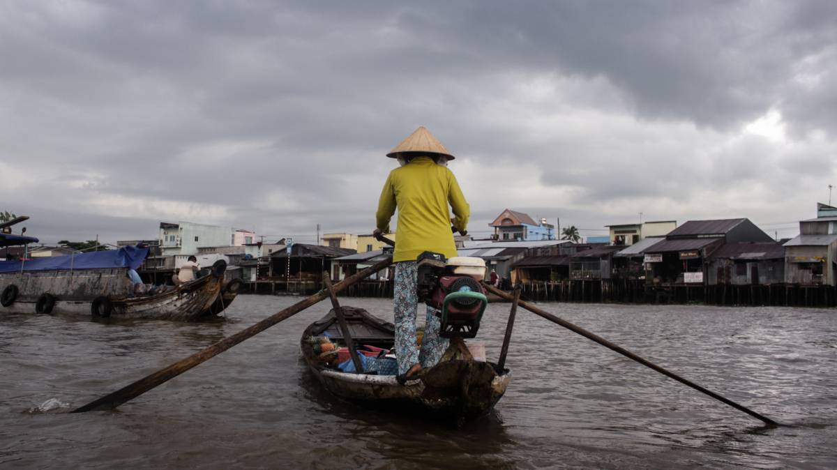 Una mujer vietnamita rema a lo largo del río en el delta del Mekong.
