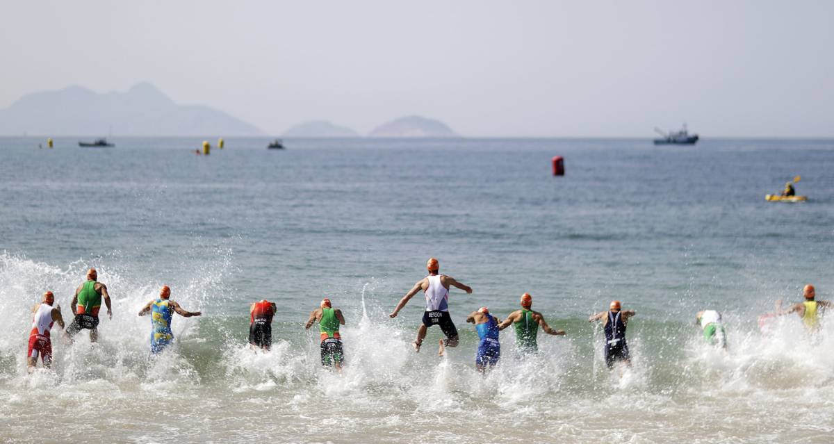 Competidores entran en el agua para la prueba de triatl&oacute;n masculino.