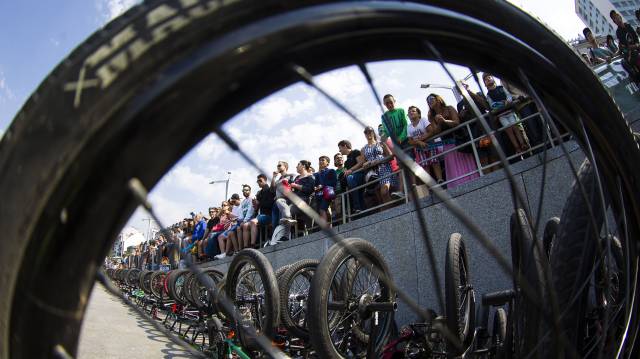 Asistentes al festival contemplan el espectáculo junto a un muro tomado por ls bicicletas que volaron sobre las calles y escalinatas de la ciudad.