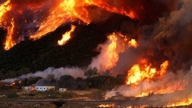 Las llamas atizadas por el fuerte viento se acercan a un camping en el condado de San Bernardino, California.