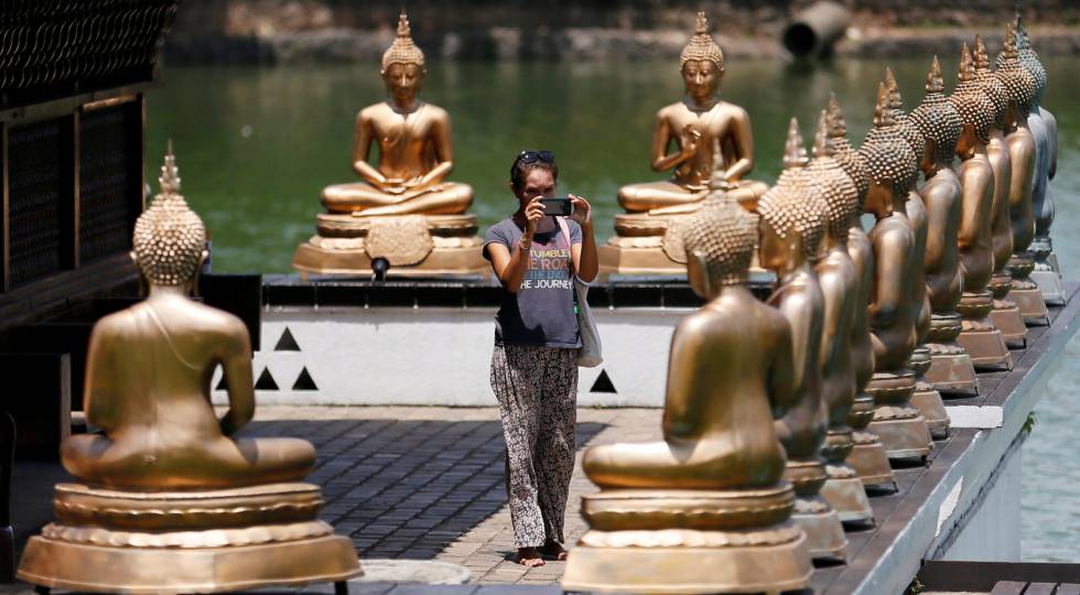 Una turista fotografÃa estatuas de Buda en un templo de Colombo, capital de Sri Lanka.