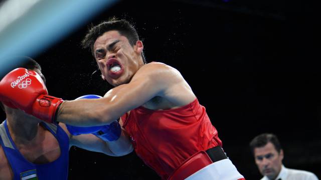 El mexicano Misael Uziel Rodriguez (rojo) lucha contra el uzbeco Bektemir Melikuziev (azul) durante la semifinal masculina.