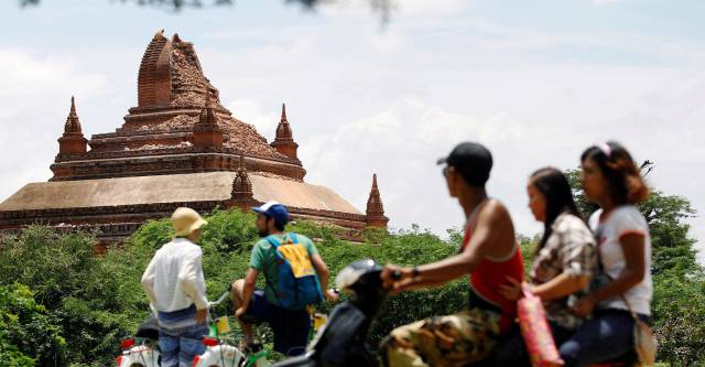 Turistas observan una padoga dañada tras el terremoto.