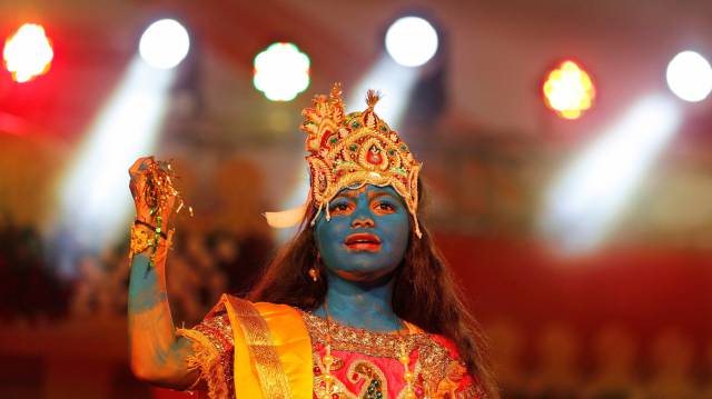 una niña disfrazada como dios Krisna realiza un espectáculo dentro de las celebraciones del Janmashtami, en Ahmedabad (India).