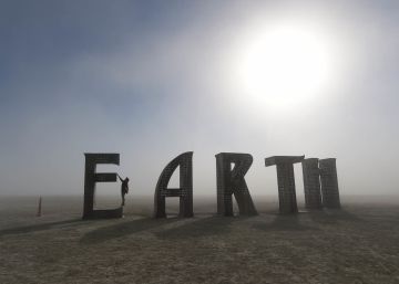 Una participante se cuelga de la letra E de la palabra Earth (Tierra), una de las esculturas del desierto de Black Rock, en Nevada, por el festival Burning Man. 