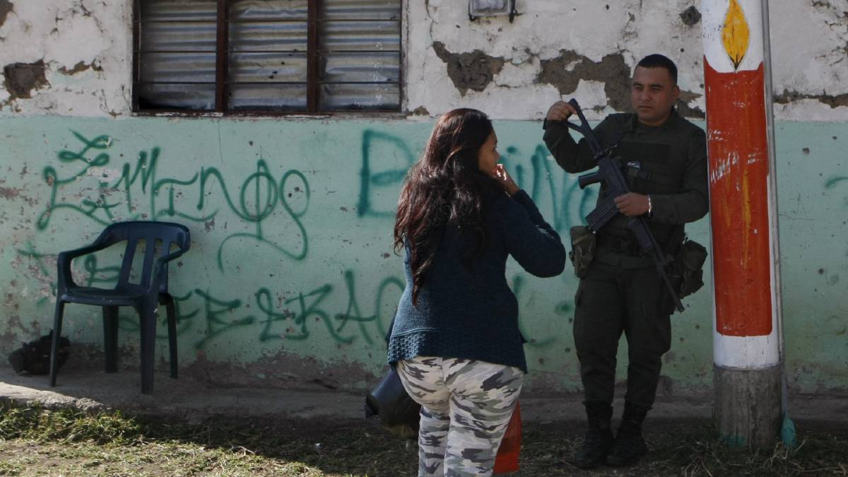 Una mujer conversa con un Polic&iacute;a en Toribio (Colombia). La normalidad reina pocas horas del cese al fuego definitivo entre las FARC.